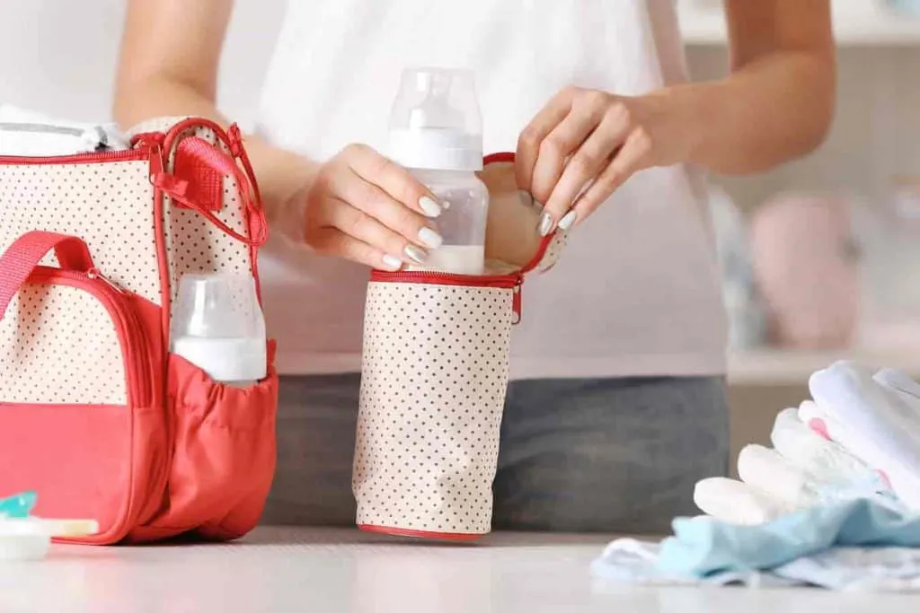 woman with baby bottle and diaper bag
