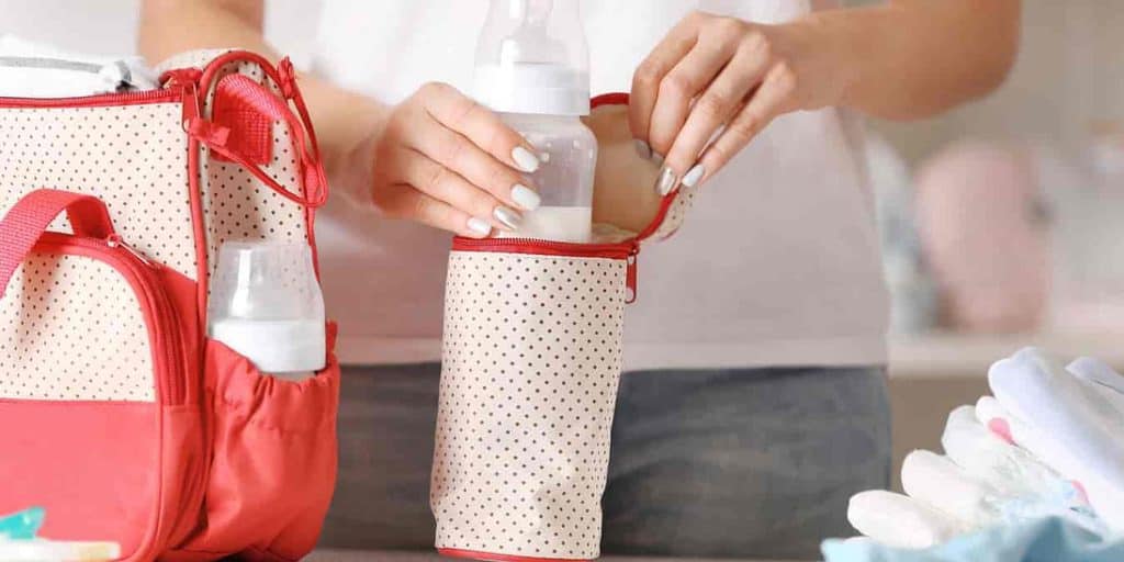 woman with baby bottle and diaper bag